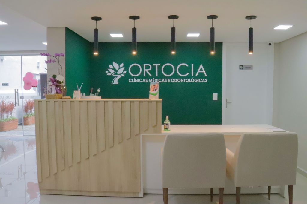 recepção principal e parede com logomarca da clínica Ortocia